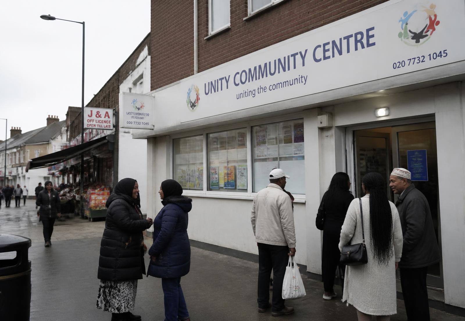 Community members gathering outside a local community centre on a UK high street